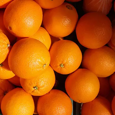Orange de saison coupée en deux sur fond blanc